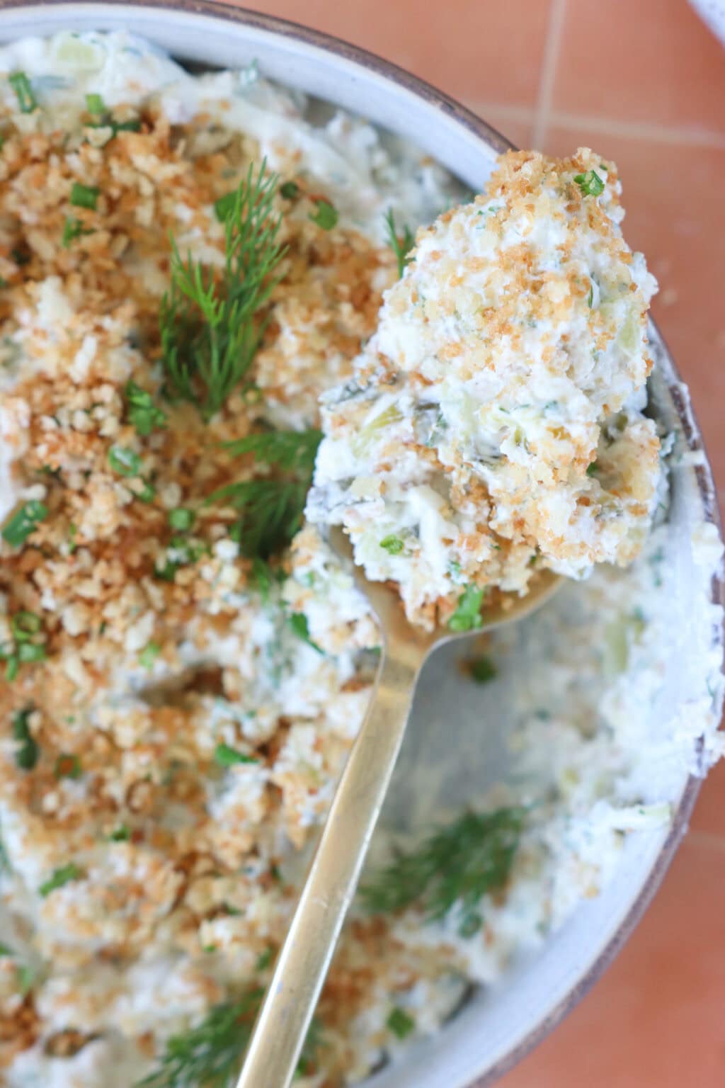 Seriously Good "Fried" Pickle Dip with Greek Yogurt in a white bowl with a scoop on a spoon