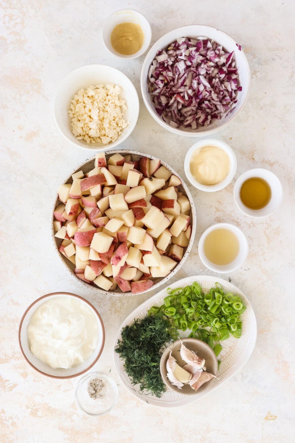 Ingredients for Red Potato Salad with Greek Yogurt Dressing, including red nugget potatoes, red onion, garlic, avocado oil, corn kernels, feta,, fresh dill, salt and pepper to taste, green onion, bacon